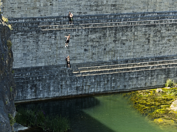 Bañista saltando desde la parte media del muro de la presa Pontón